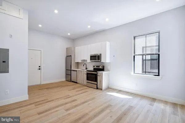a kitchen with stainless steel appliances a stove top oven a sink and a refrigerator