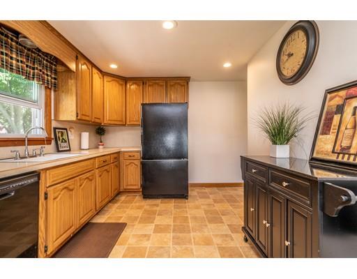 91 Mildred Avenue Springfield, MA 01104 - Photo 13 of 41 a kitchen with granite countertop a refrigerator a stove a sink and a dining table with wooden floor