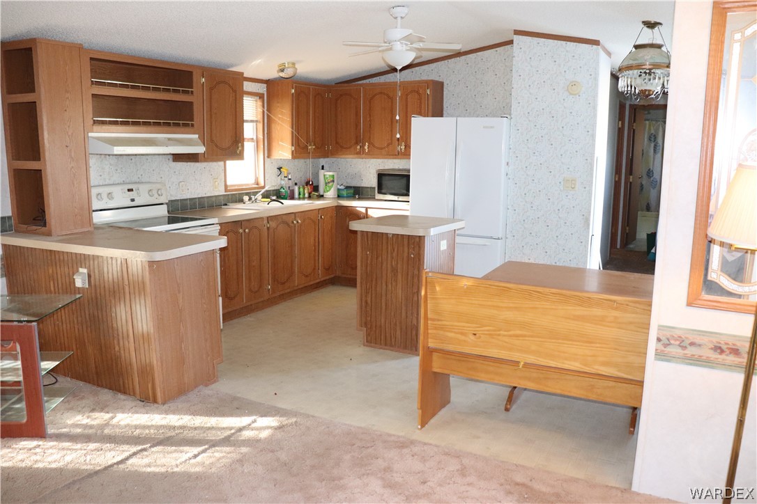 884 Elgin Road Golden Valley, AZ 86413 - Photo 3 of 26 a kitchen with kitchen island a counter top space a sink a refrigerator and a window