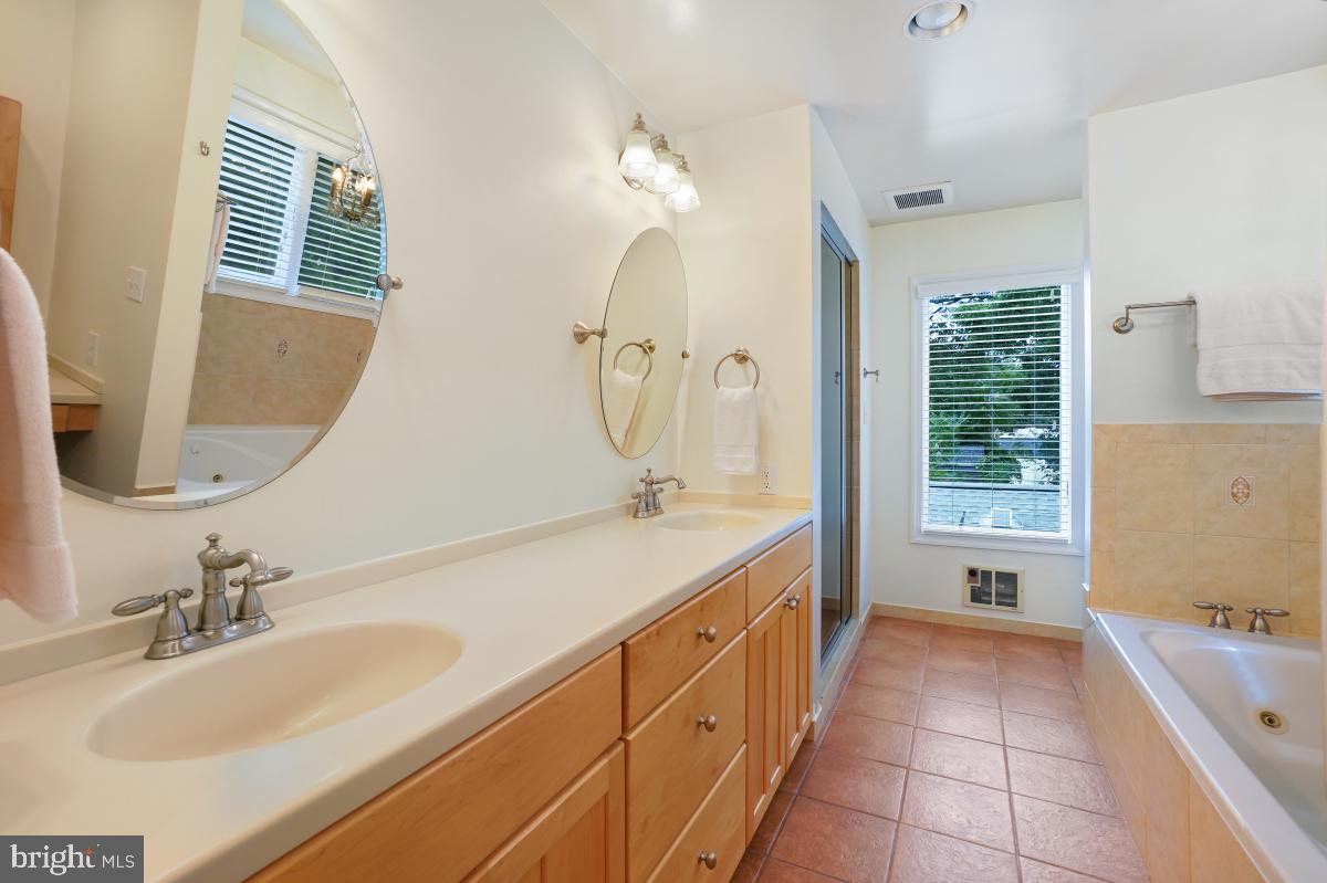 412 Silver Spring Avenue Silver Spring, MD 20910 - Photo 35 of 48 a spacious bathroom with a double vanity sink a large mirror and a bathtub