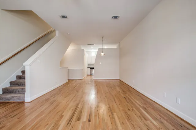 a view of empty room with wooden floor