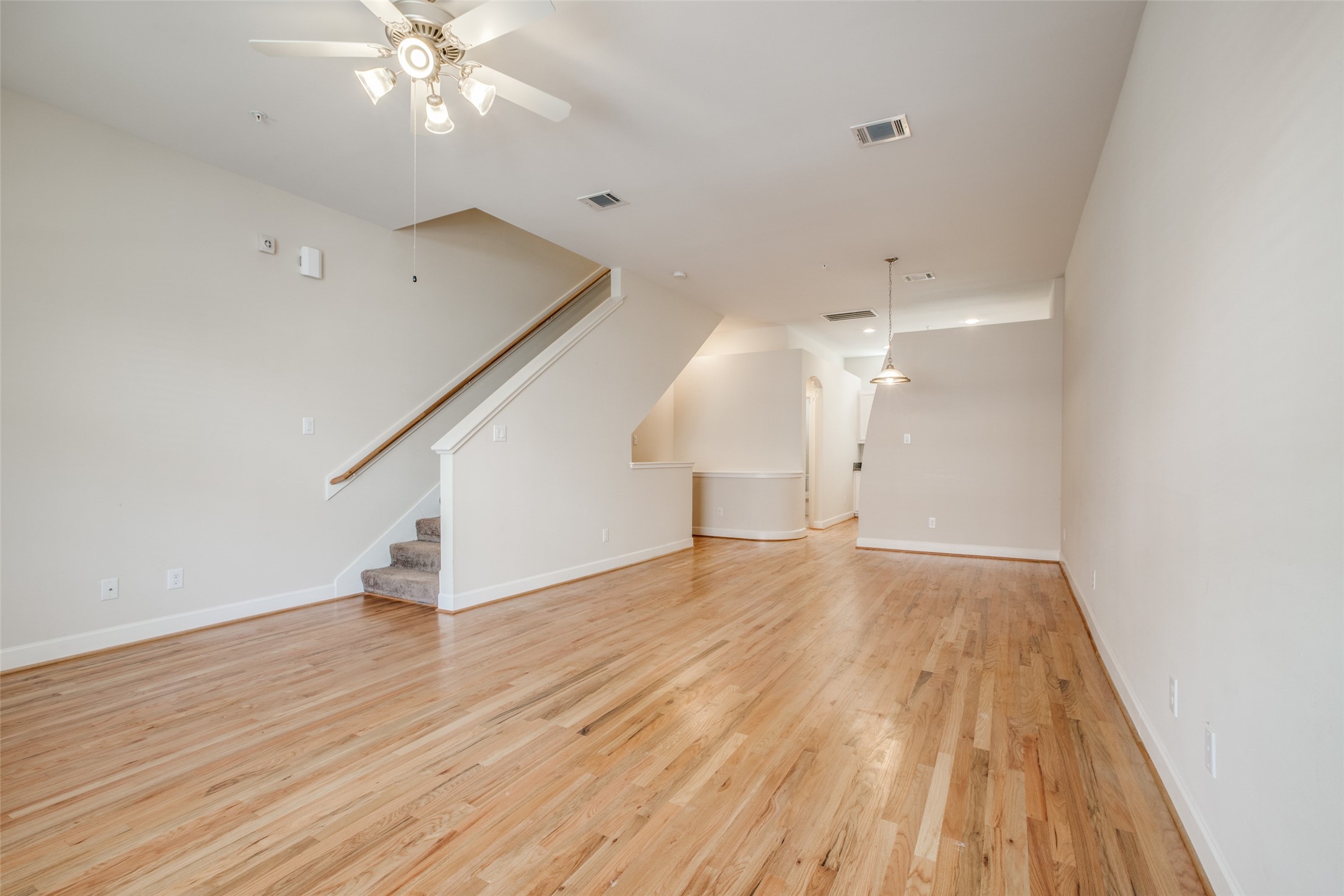 2710 Hullsmith Drive, Unit 401 Houston, TX 77063 - Photo 15 of 25 an empty room with wooden floor and staircase