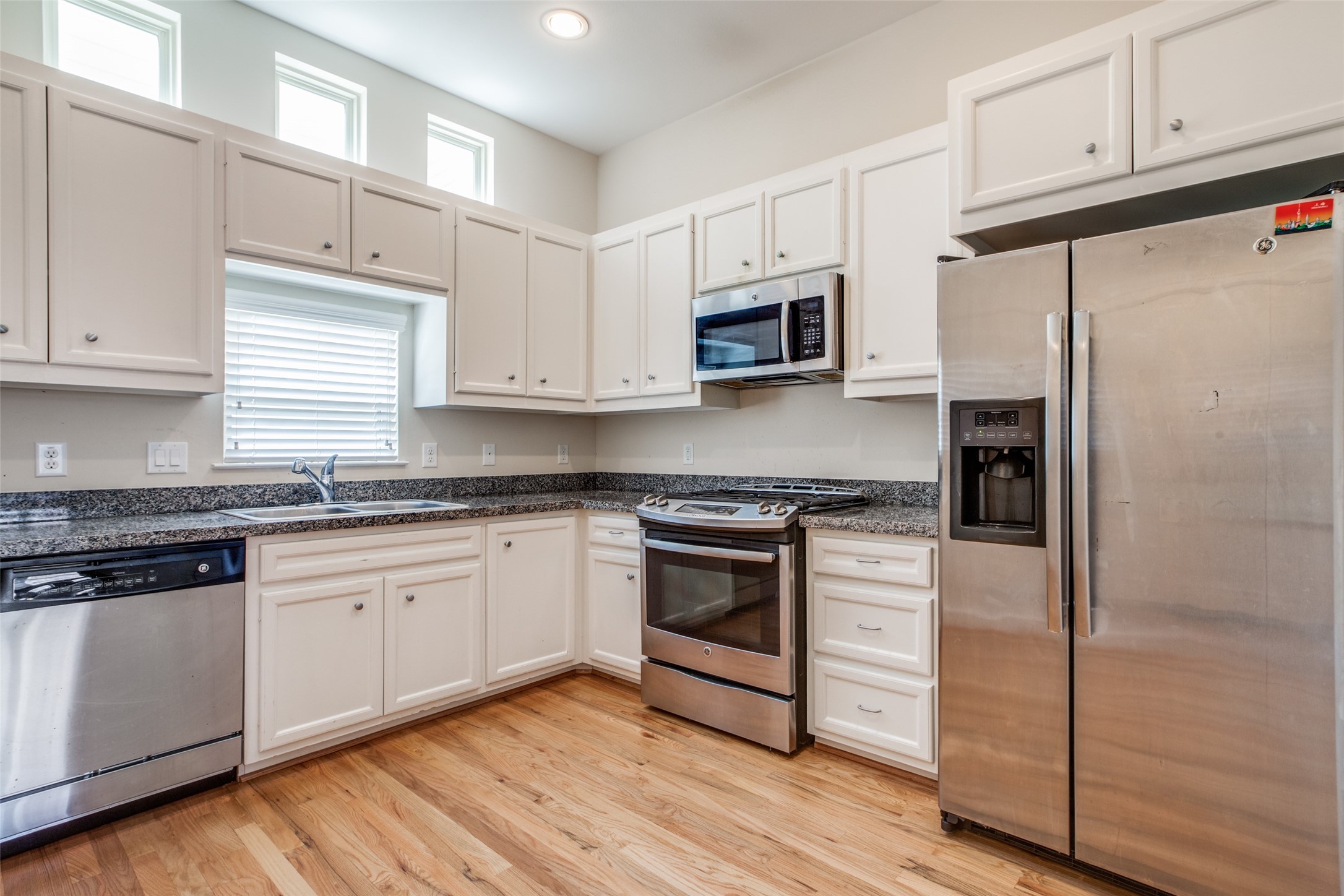 2710 Hullsmith Drive, Unit 401 Houston, TX 77063 - Photo 16 of 25 a kitchen with granite countertop white cabinets and stainless steel appliances