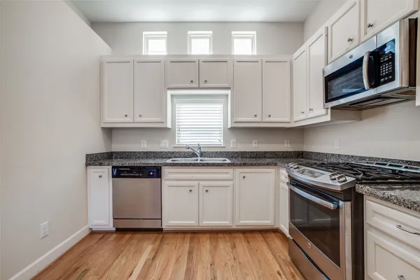 a kitchen with stainless steel appliances granite countertop a stove and a microwave