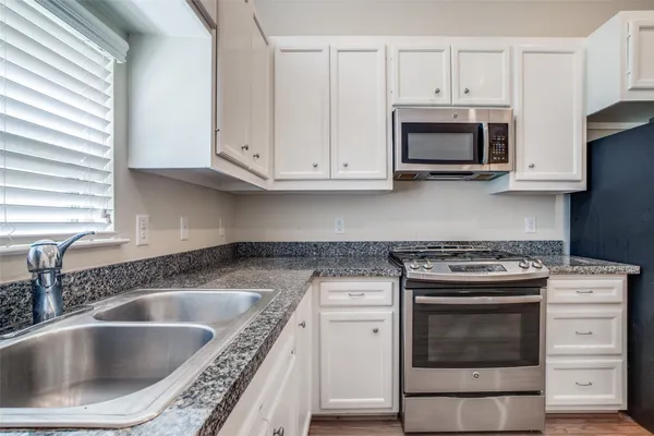 a kitchen with white cabinets and stainless steel appliances