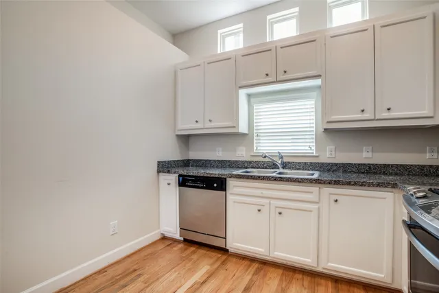a kitchen with granite countertop wooden cabinets and a sink