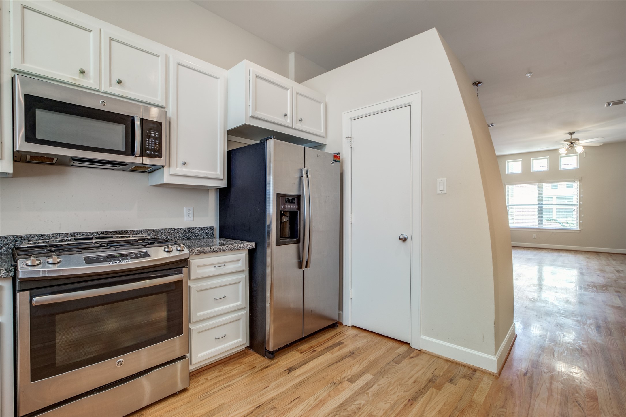2710 Hullsmith Drive, Unit 401 Houston, TX 77063 - Photo 20 of 25 a kitchen with stainless steel appliances a stove a microwave oven cabinets and wooden floor