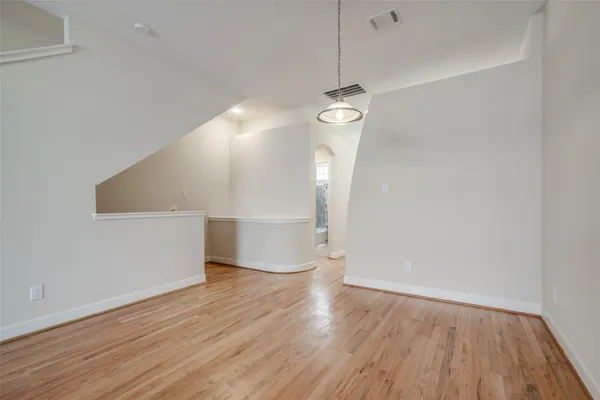 a view of empty room with wooden floor