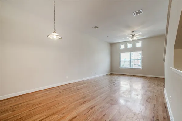 a view of empty room with wooden floor