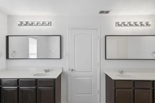 a bathroom with a sink vanity and a mirror
