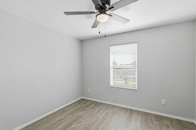 an empty room with a window and a fan