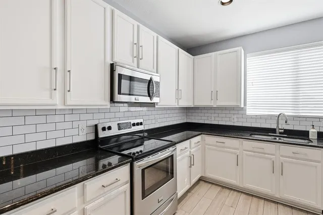 a kitchen with granite countertop white cabinets and white appliances