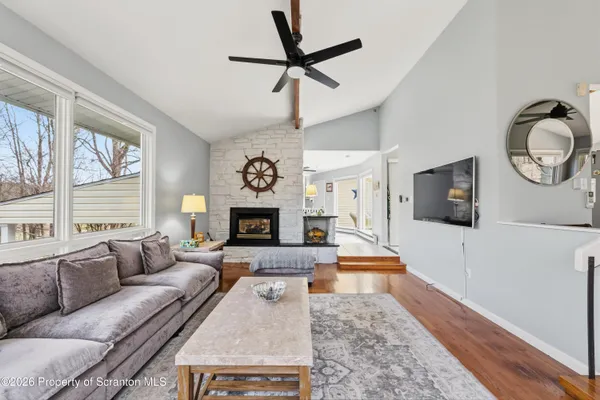 a living room with furniture a flat screen tv and a fireplace