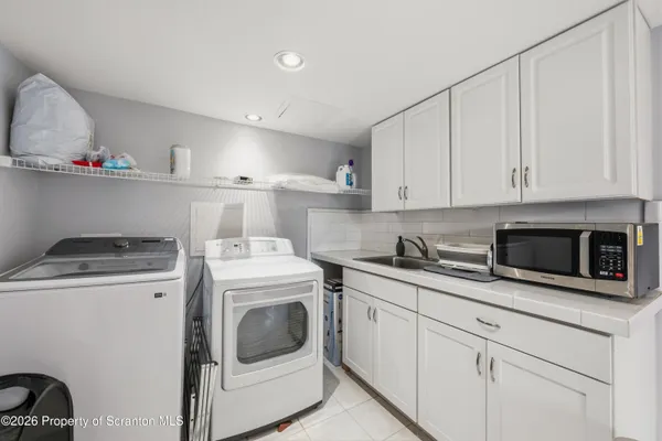 a kitchen with white cabinets and white appliances