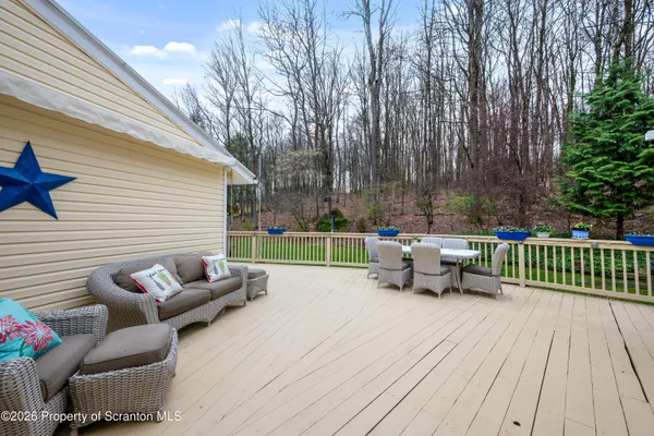 a view of a deck with furniture and garden