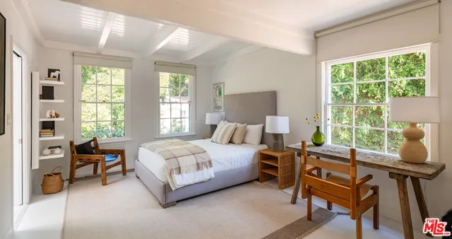 a bedroom with a bed and large windows