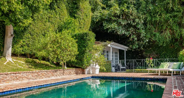 a view of house with swimming pool and yard