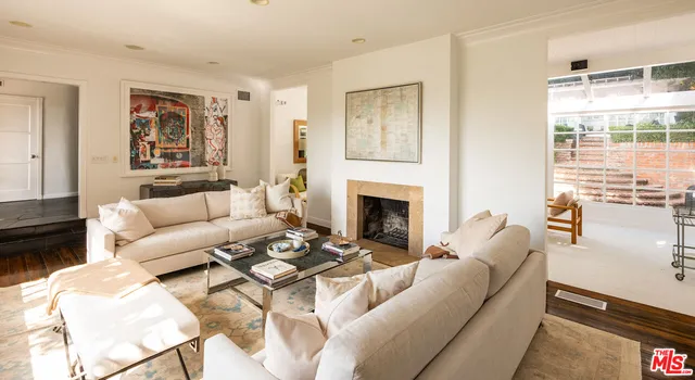 a living room with furniture a large window and a fireplace