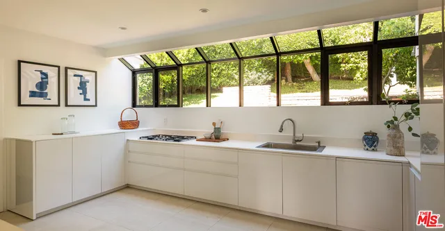 a kitchen with a sink window and cabinets