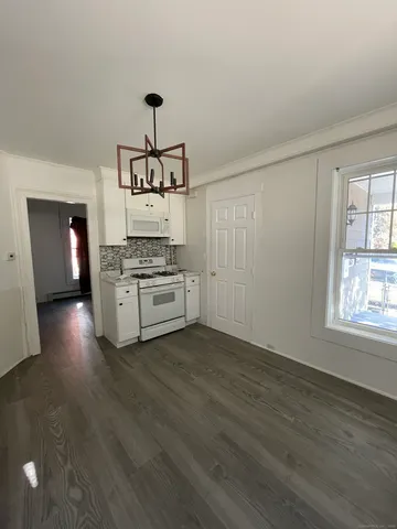 a kitchen with granite countertop a stove and a wooden floors