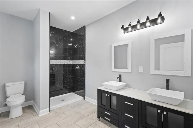 a bathroom with a sink a toilet and shower