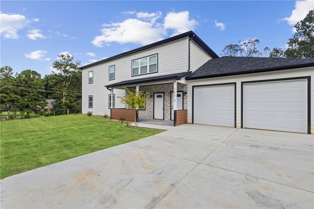 1275 Riverside Road Sugar Hill, GA 30518 - Photo 5 of 17 a front view of a house with a yard and garage