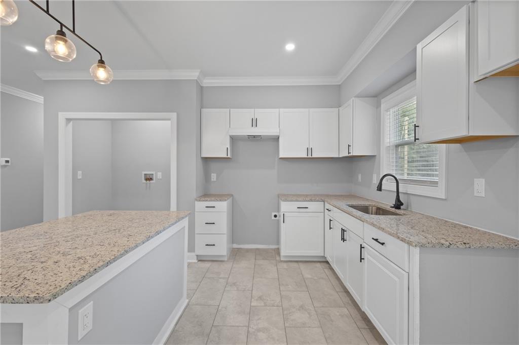 1275 Riverside Road Sugar Hill, GA 30518 - Photo 9 of 17 a kitchen with a sink stove and cabinets