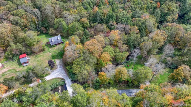 an aerial view of residential houses with outdoor space and trees