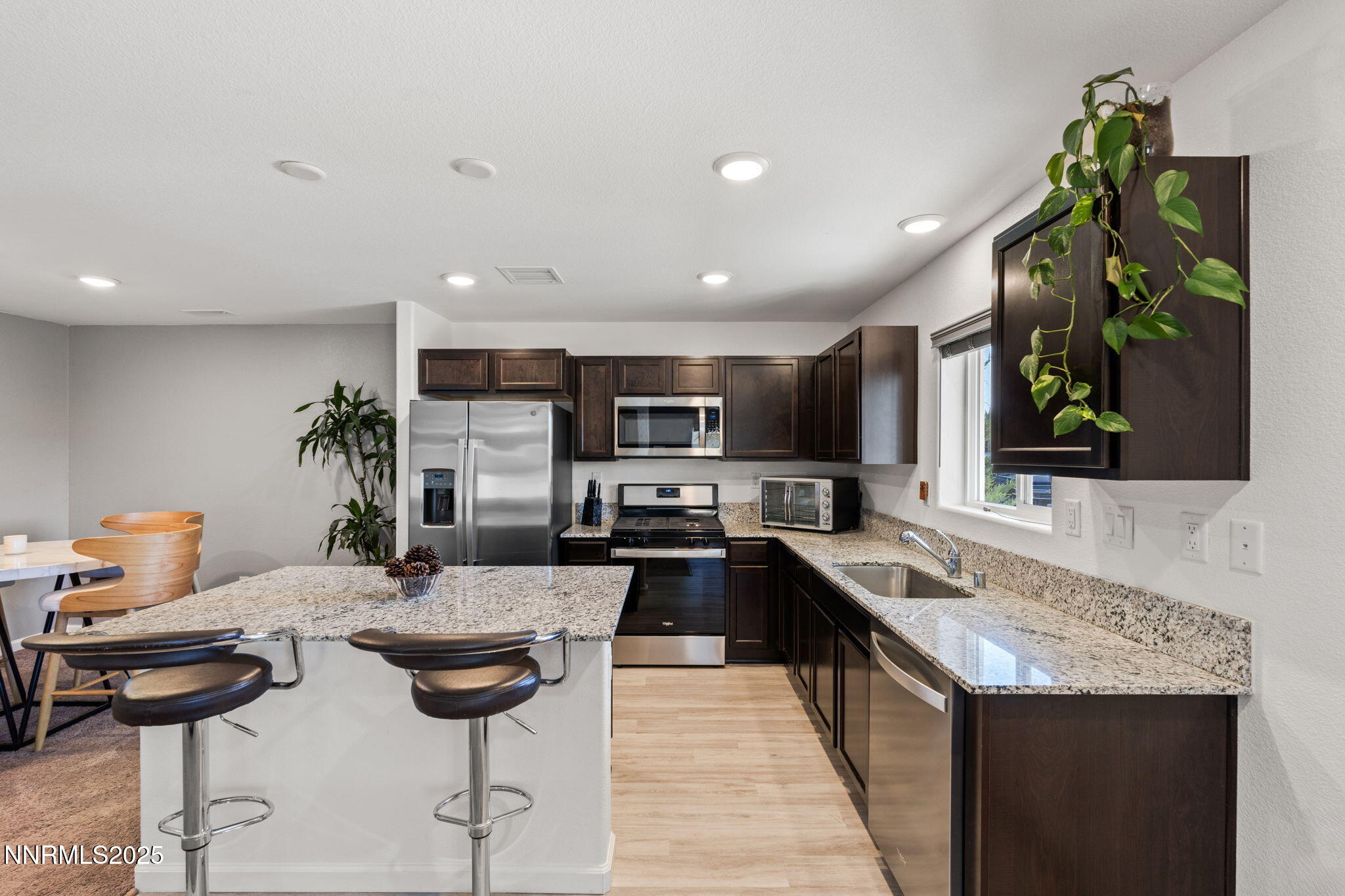 673 Mcgill Drive Reno, NV 89506 - Photo 7 of 34 a kitchen with stainless steel appliances kitchen island granite countertop a sink and cabinets