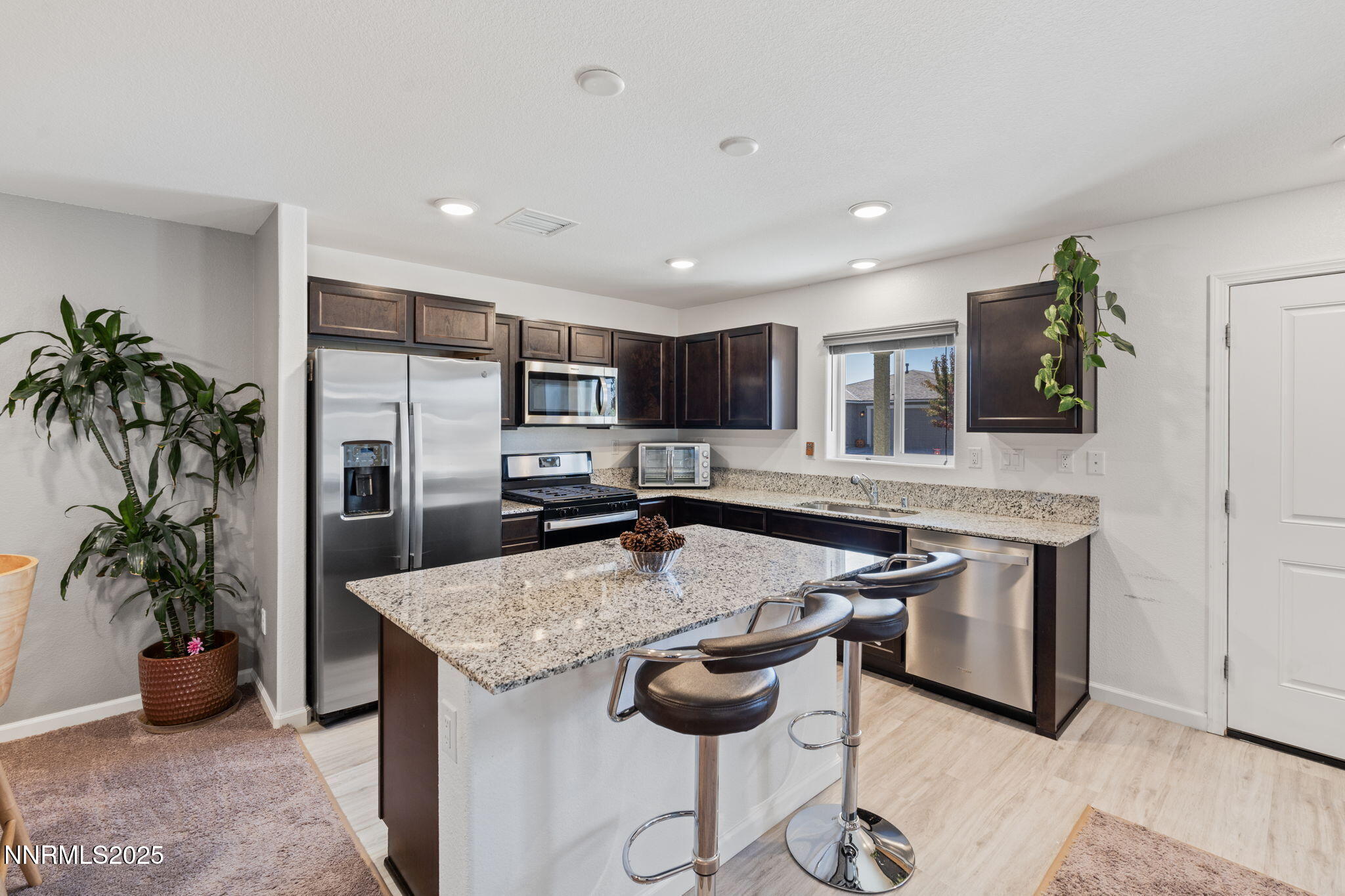 673 Mcgill Drive Reno, NV 89506 - Photo 8 of 34 a kitchen with stainless steel appliances granite countertop a stove a sink a refrigerator and a counter space
