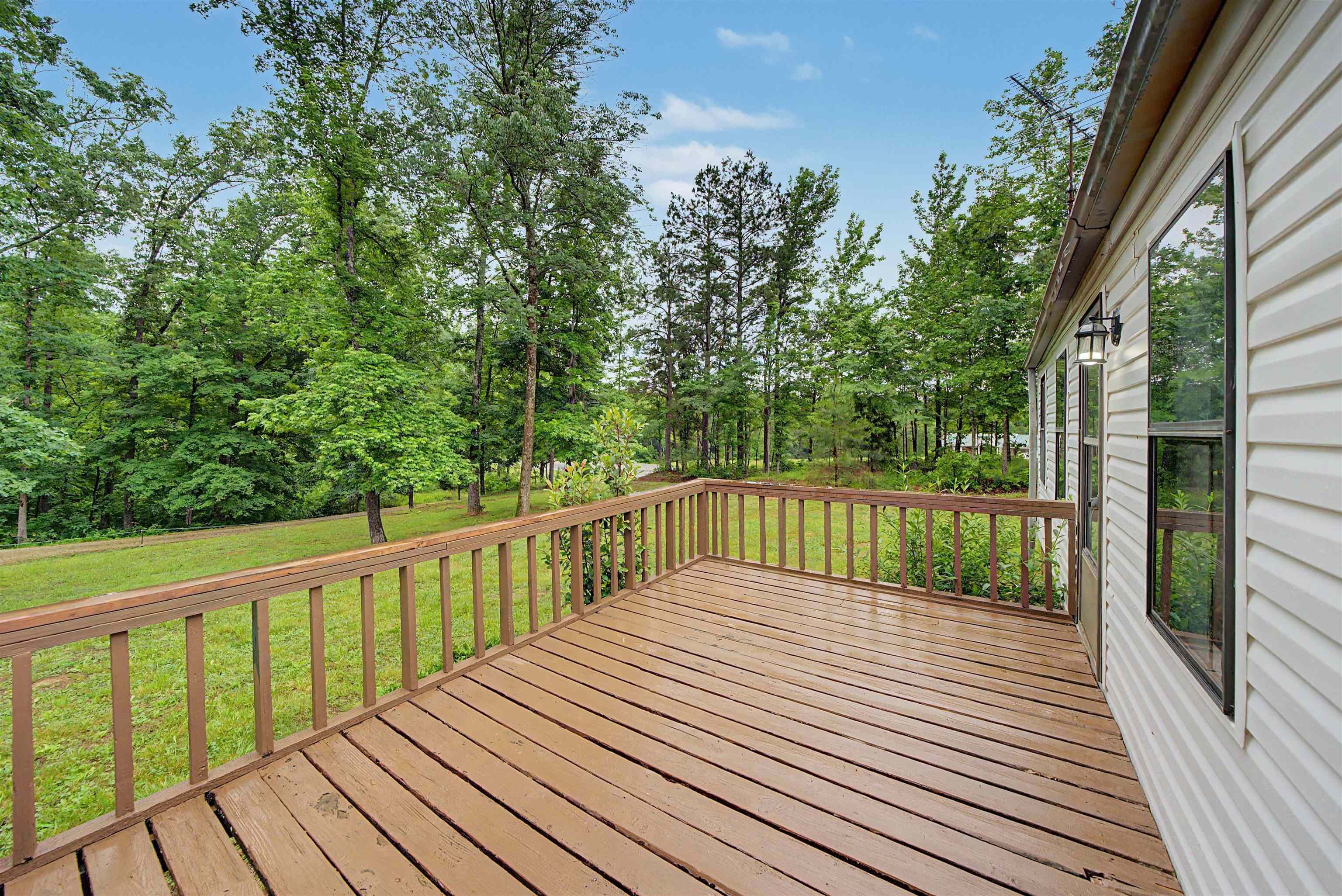 6264 45th Highway South Ramer, TN 38367 - Photo 3 of 24 Expansive wood deck with a natural finish, featuring a full railing system
