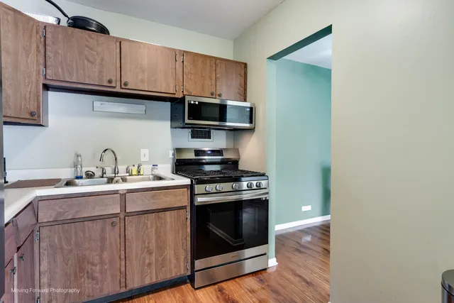 a kitchen with stainless steel appliances granite countertop a sink stove and microwave