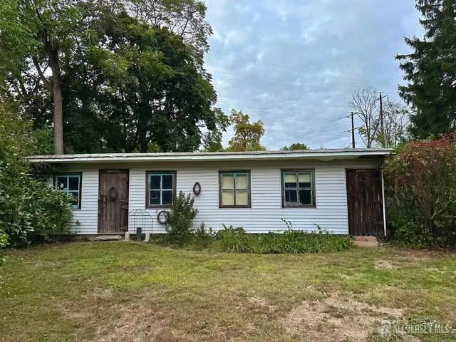 a front view of house with yard and trees in the background