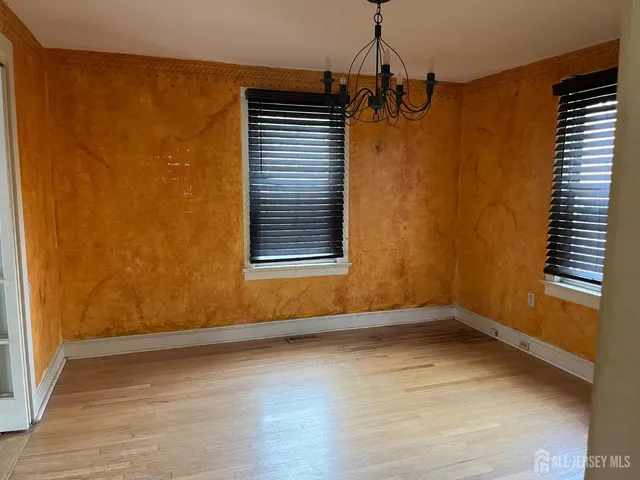 a view of a room with wooden floor and a window