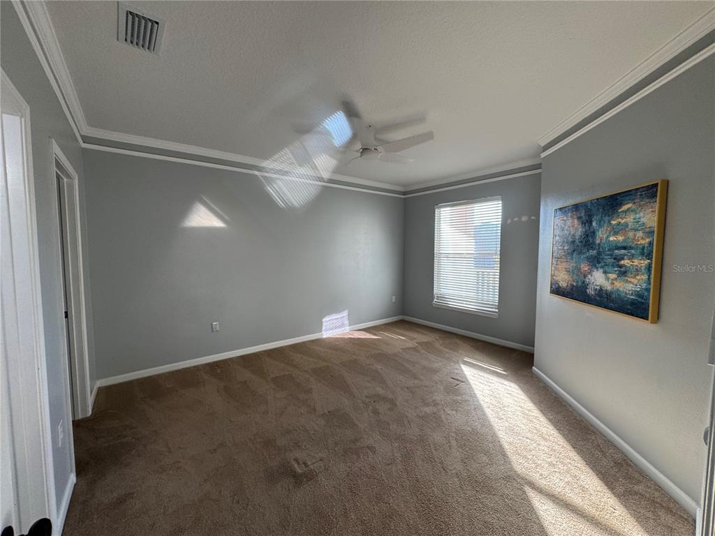 10444 Villa View Circle Tampa, FL 33647 - Photo 18 of 29 an empty room with windows and fan