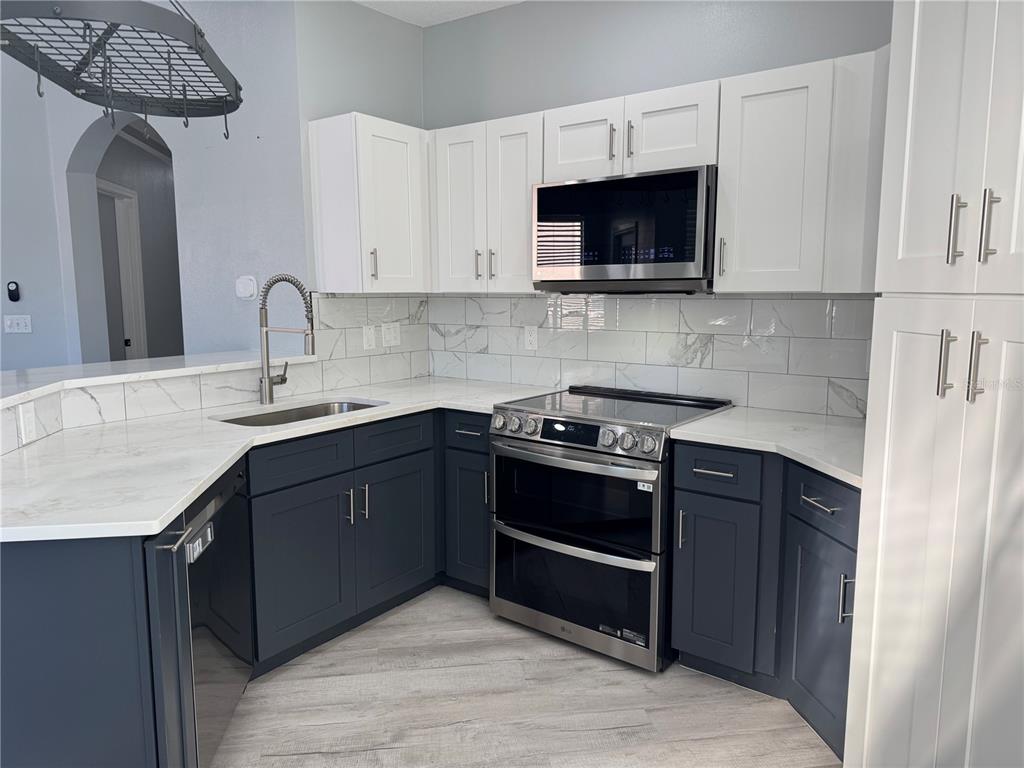 10444 Villa View Circle Tampa, FL 33647 - Photo 2 of 29 a kitchen with stainless steel appliances granite countertop a stove a sink and a microwave