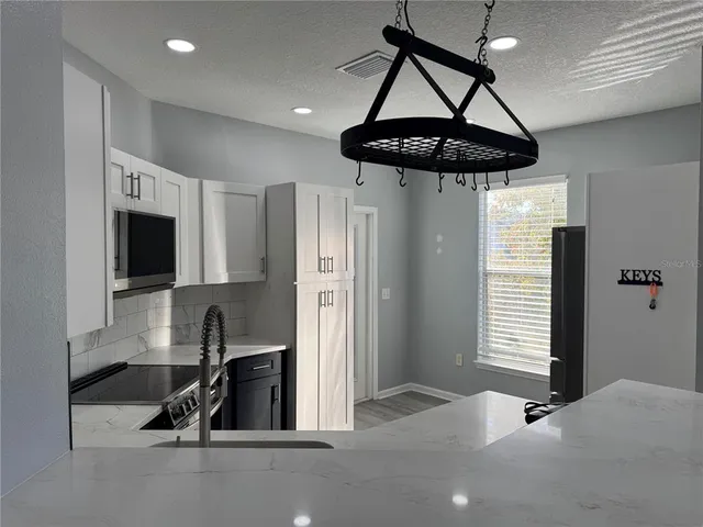 a kitchen with stainless steel appliances granite countertop a refrigerator a sink and a stove