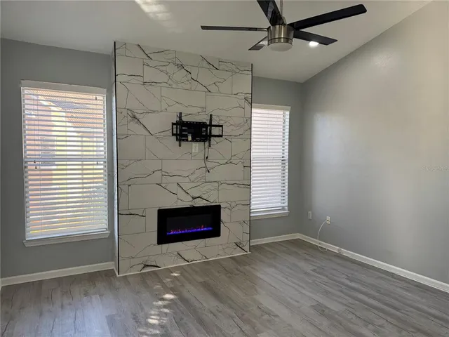 an empty room with windows and fireplace