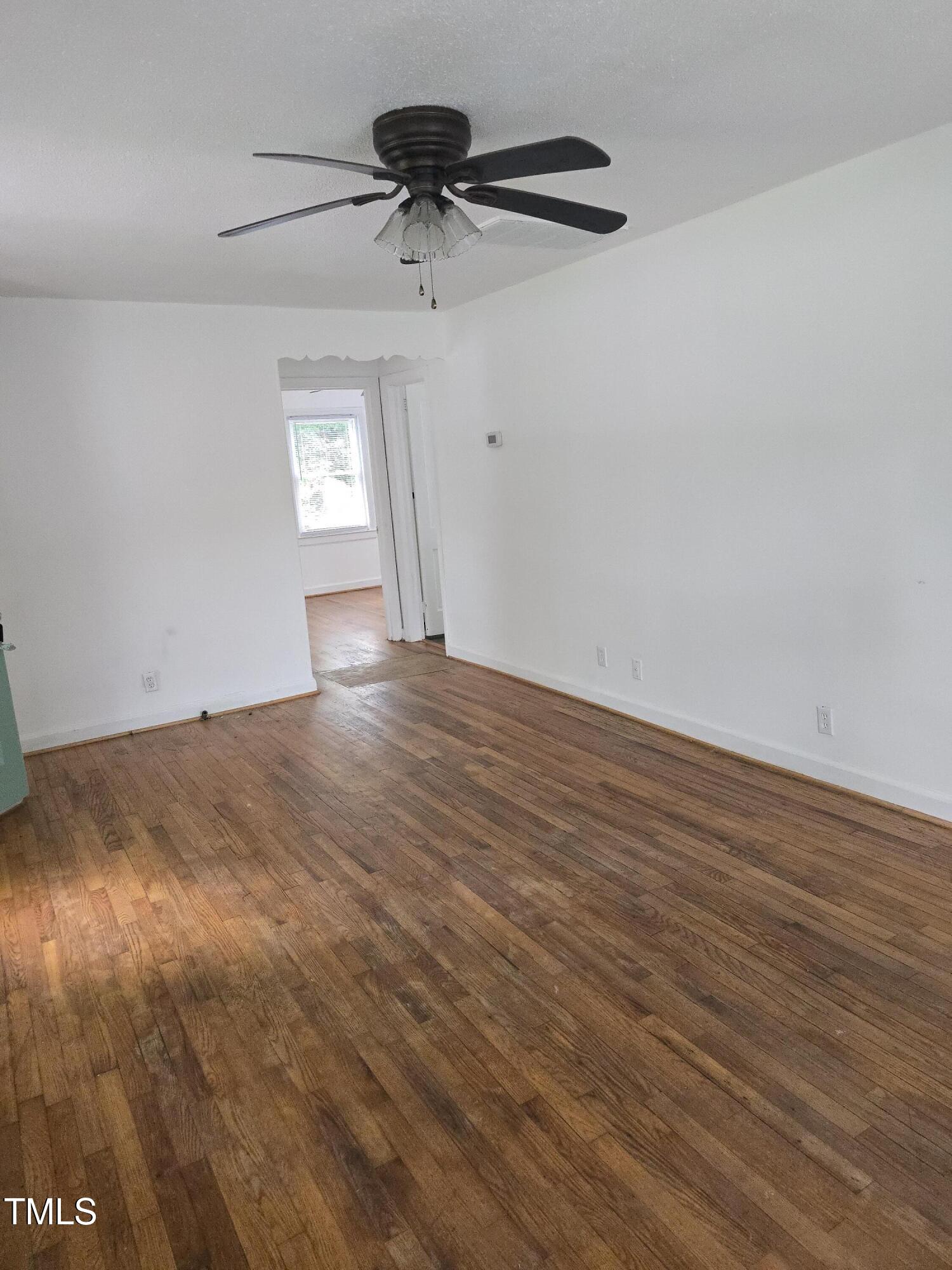 704 North King Charles Road Raleigh, NC 27610 - Photo 3 of 7 a view of an empty room with a window and wooden floor