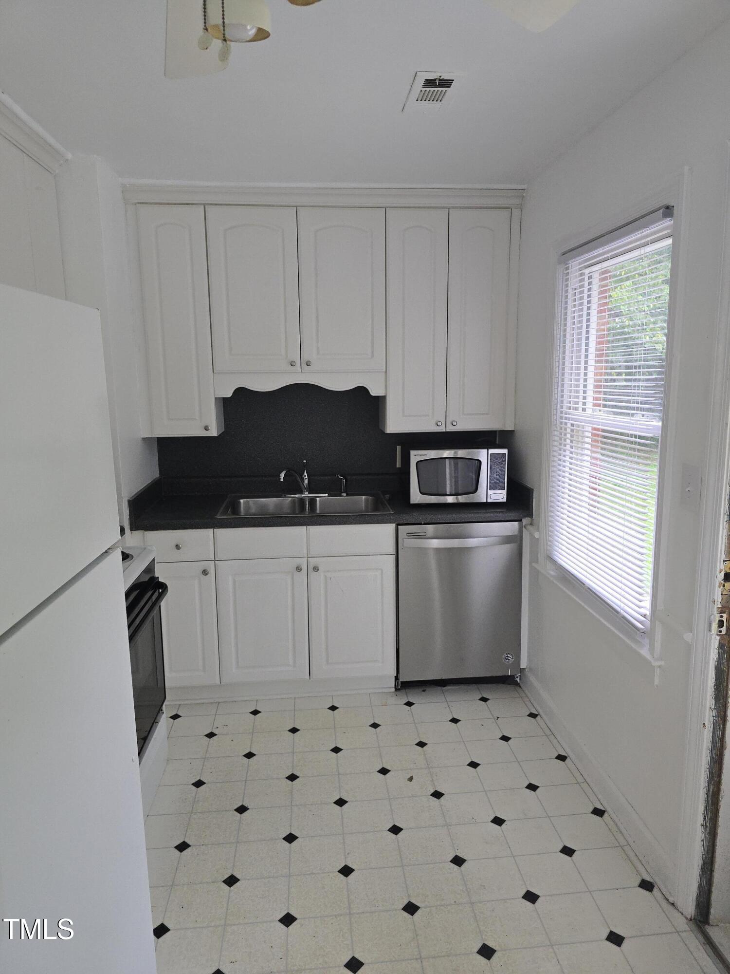704 North King Charles Road Raleigh, NC 27610 - Photo 5 of 7 a kitchen with granite countertop white cabinets and stainless steel appliances