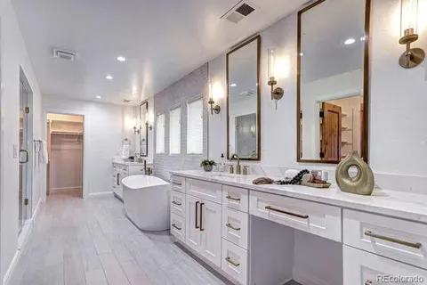 a large bathroom with double vanity sinks a large mirror and a shower