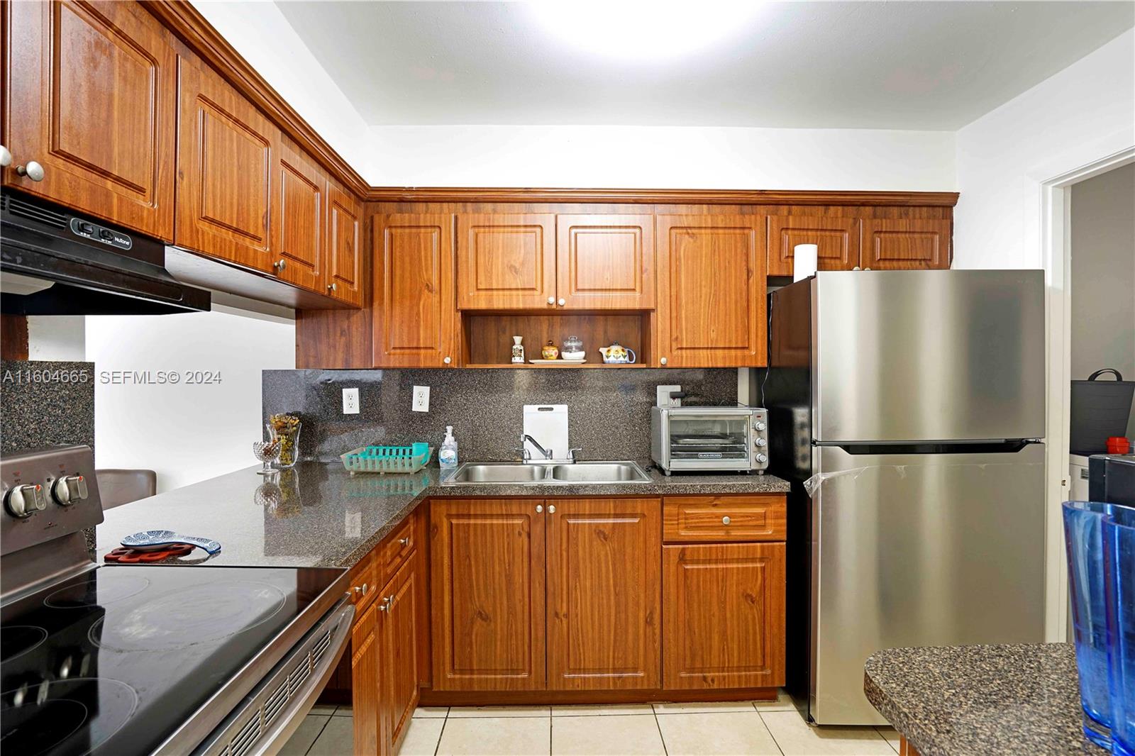624 Northwest 11th Street Miami, FL 33136 - Photo 20 of 26 a kitchen with stainless steel appliances granite countertop a refrigerator a sink and a stove