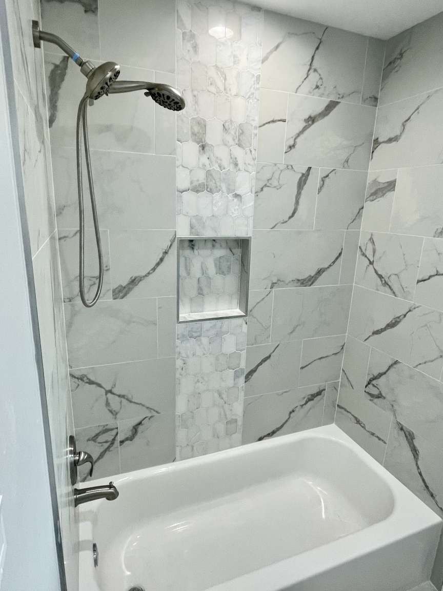 12122 Chimney Rock Road Houston, TX 77035 - Photo 20 of 33 a bathroom with a white bath tub and a shower