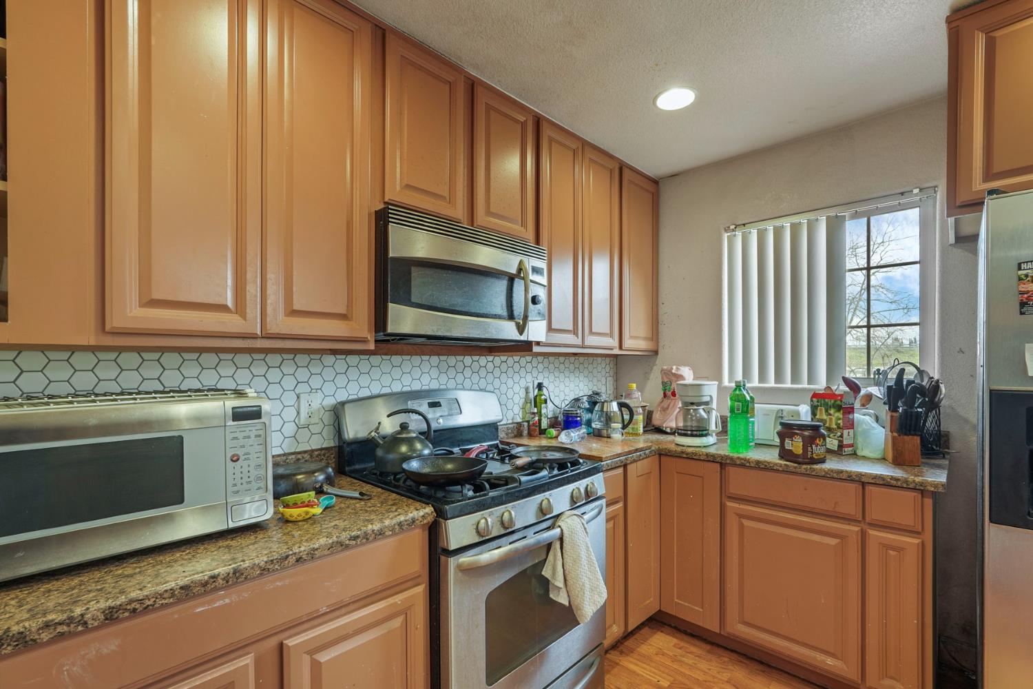 1234 Perry Avenue Stockton, CA 95203 - Photo 13 of 30 a kitchen with stainless steel appliances granite countertop a sink stove and microwave