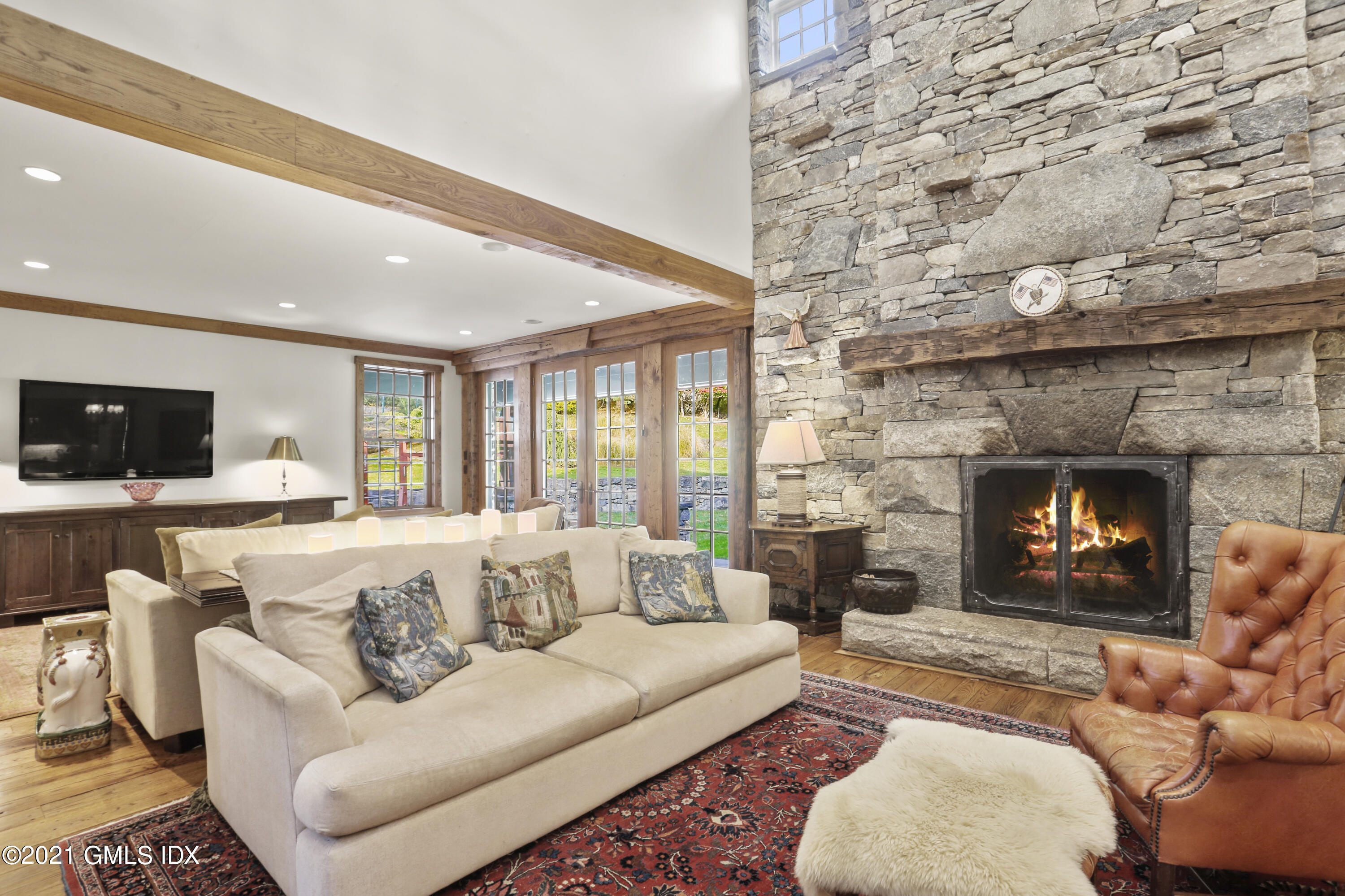 142 Cat Rock Road Cos Cob, CT 06807 - Photo 5 of 27 a living room with furniture a flat screen tv and a fireplace