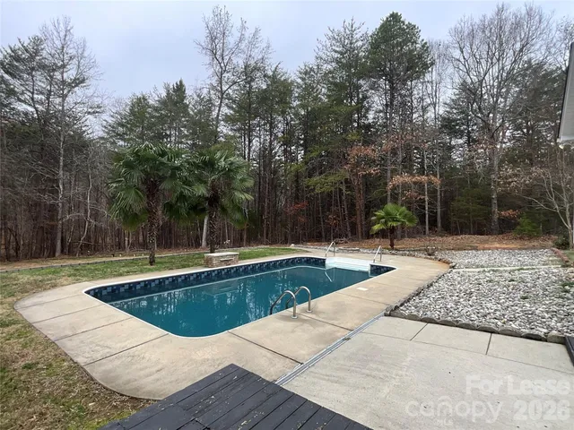 a view of swimming pool with trees in the background