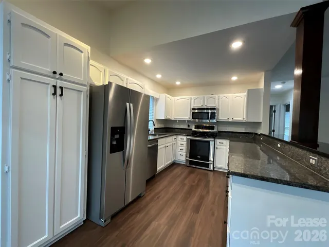 a kitchen with a refrigerator and a stove top oven