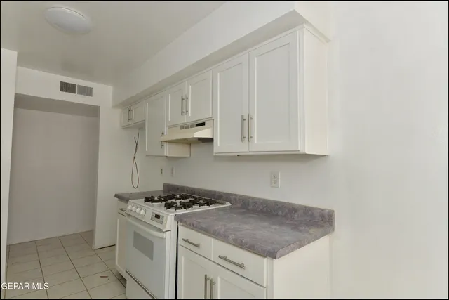 a white stove top oven sitting inside of a kitchen