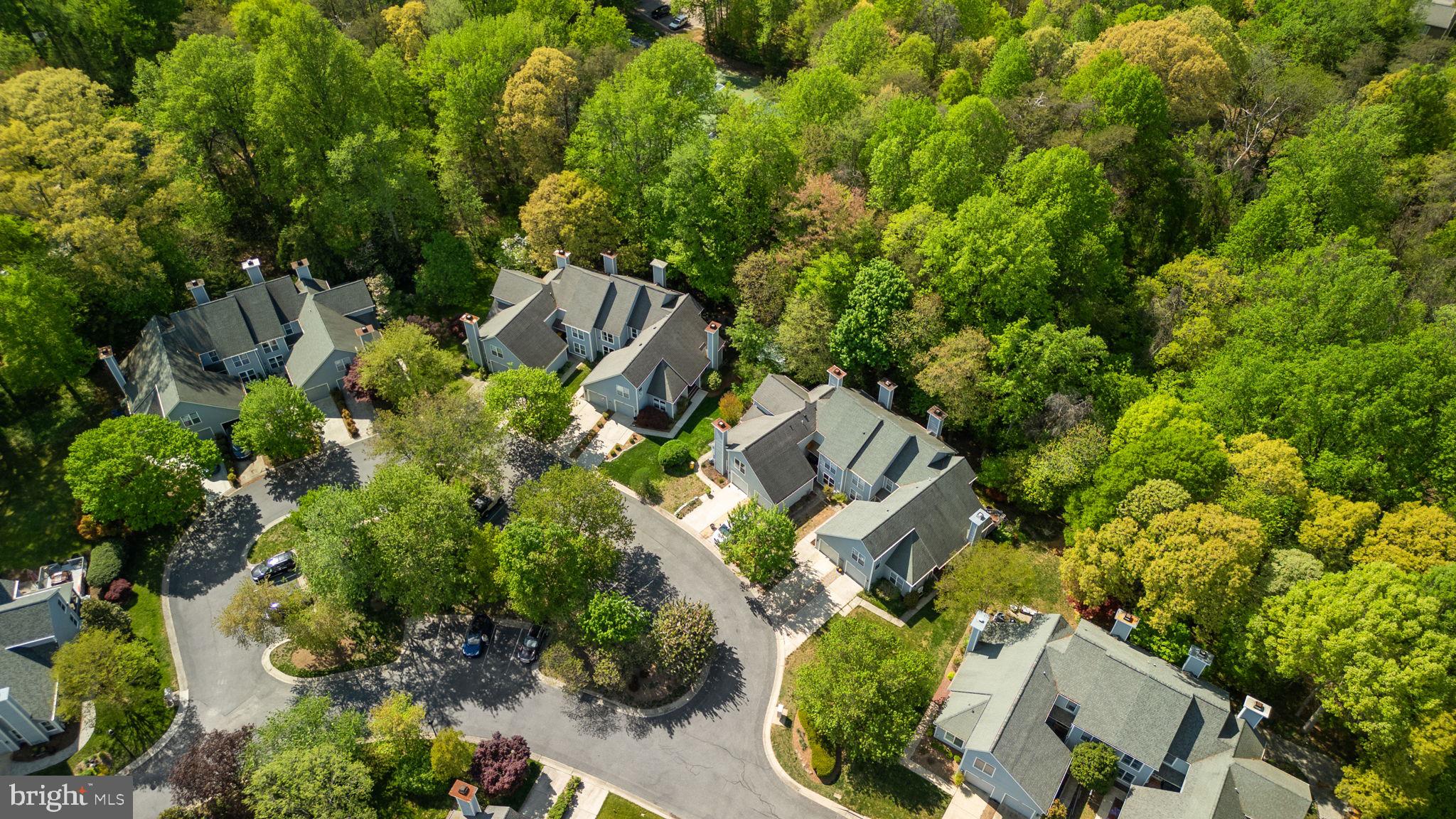 an aerial view of a house with a yard and lots of trees