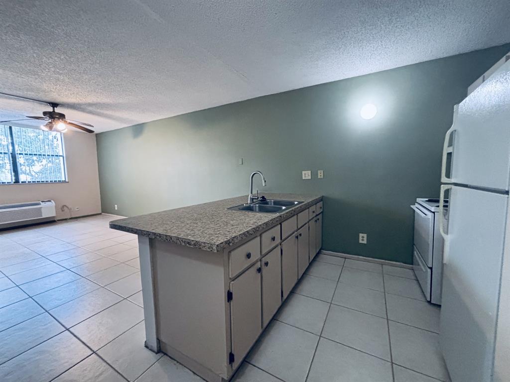 2401 Riverside Drive, Unit 311B Coral Springs, FL 33065 - Photo 5 of 12 a kitchen with a sink a vanity and window